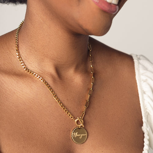 A close-up image of a woman wearing a 18K gold plated chain necklace with a round pendant engraved with "Nkosazana"